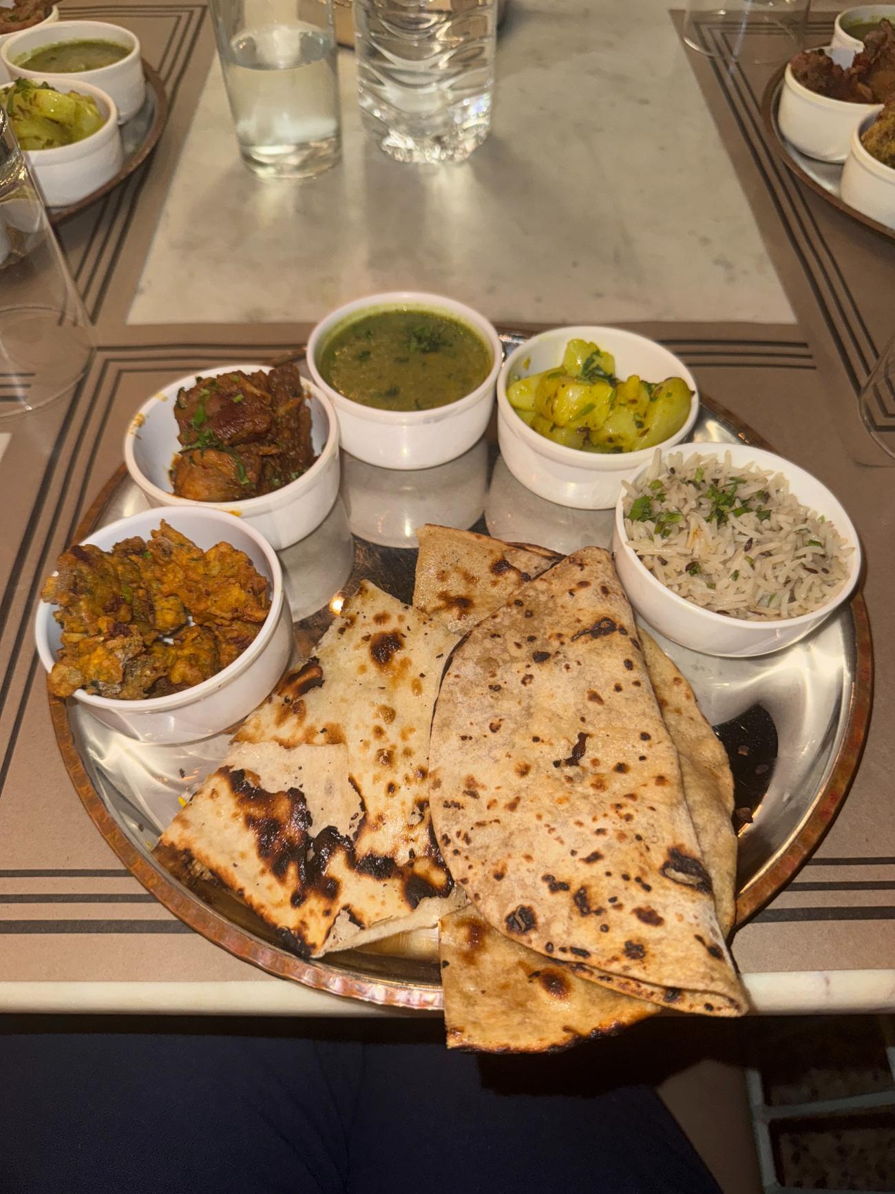 Indian food on a serving tray with naan